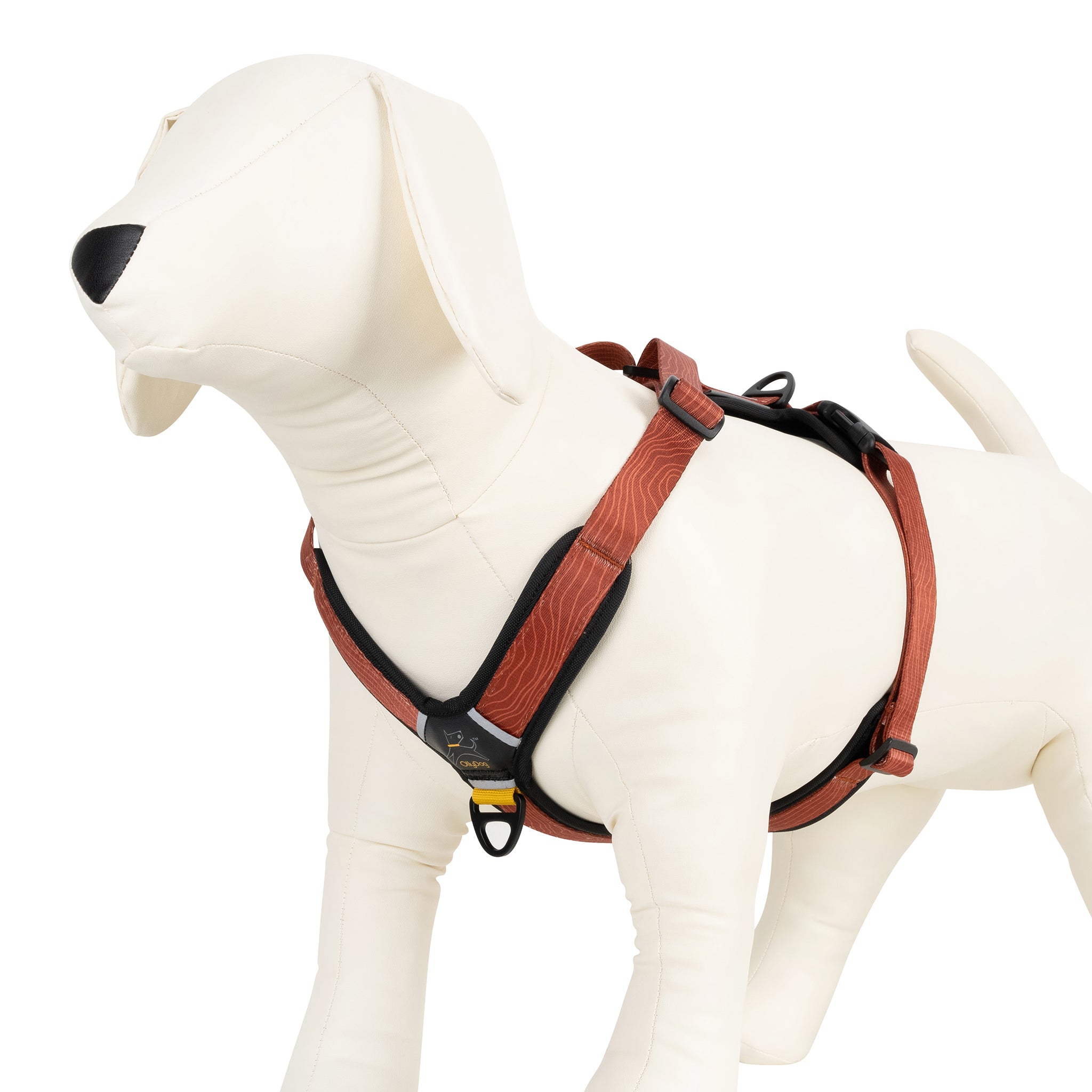 Dog mannequin wearing the OllyDog Alpine Reflective Comfort Harness in Clay color with woodgrain pattern, showcasing padded chest and belly straps, sturdy aluminum D-ring, and adjustable fit for secure wear #color_clay woodgrain