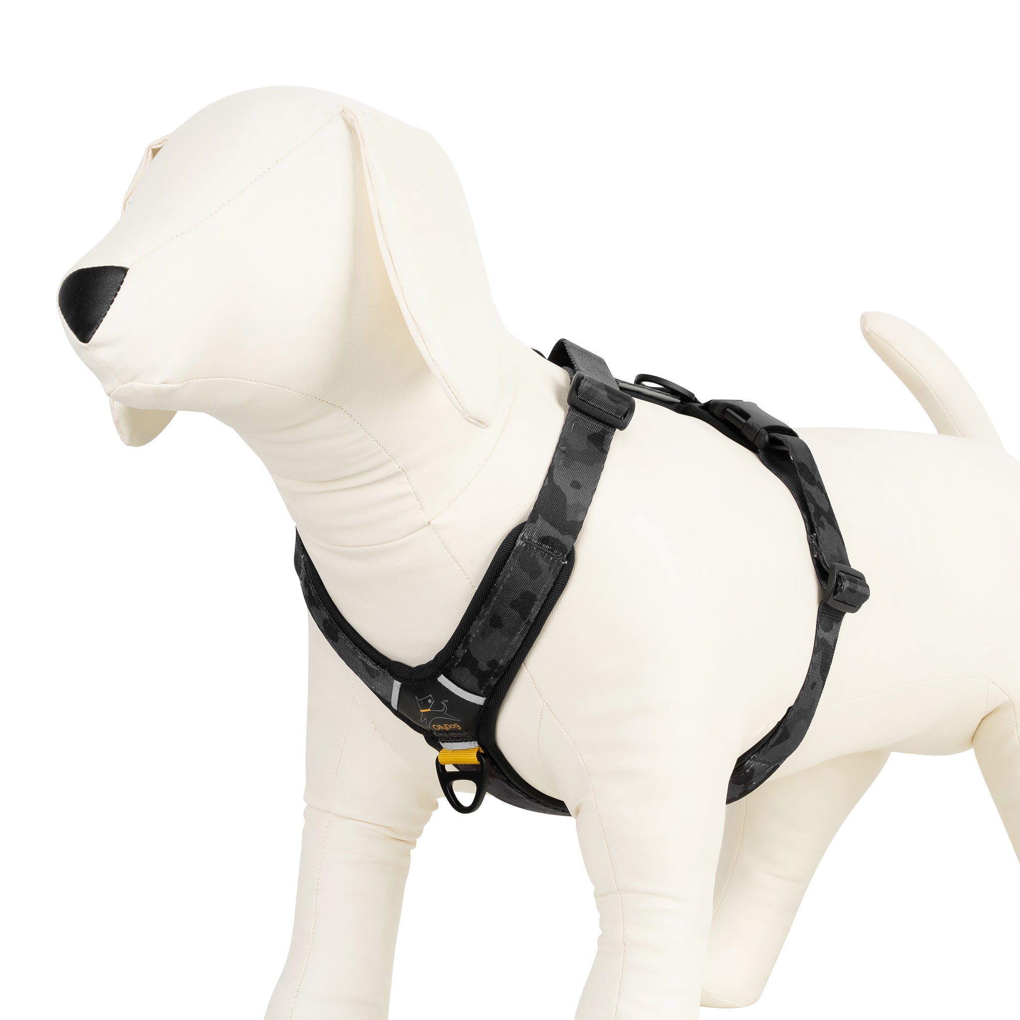 OllyDog Alpine Reflective Comfort Harness in Dream Camo color, shown on a white mannequin dog. The harness features a dark camouflage pattern with padded adjustable straps, metal D-ring, and reflective detailing #color_dream camo