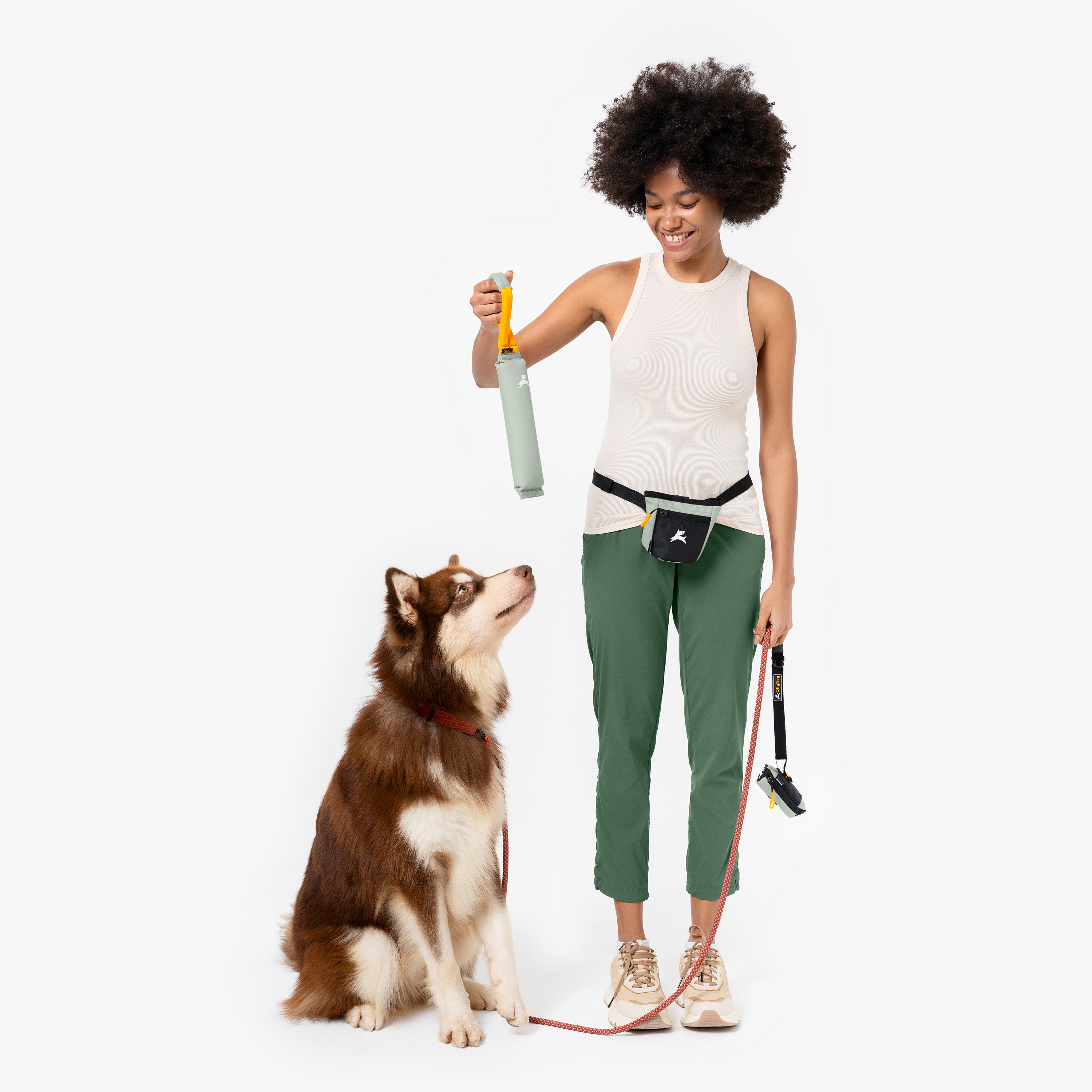 Woman training a Husky with dog walking essentials — treat fanny pack, leash, and toy, perfect for active dog owners #color_celadon