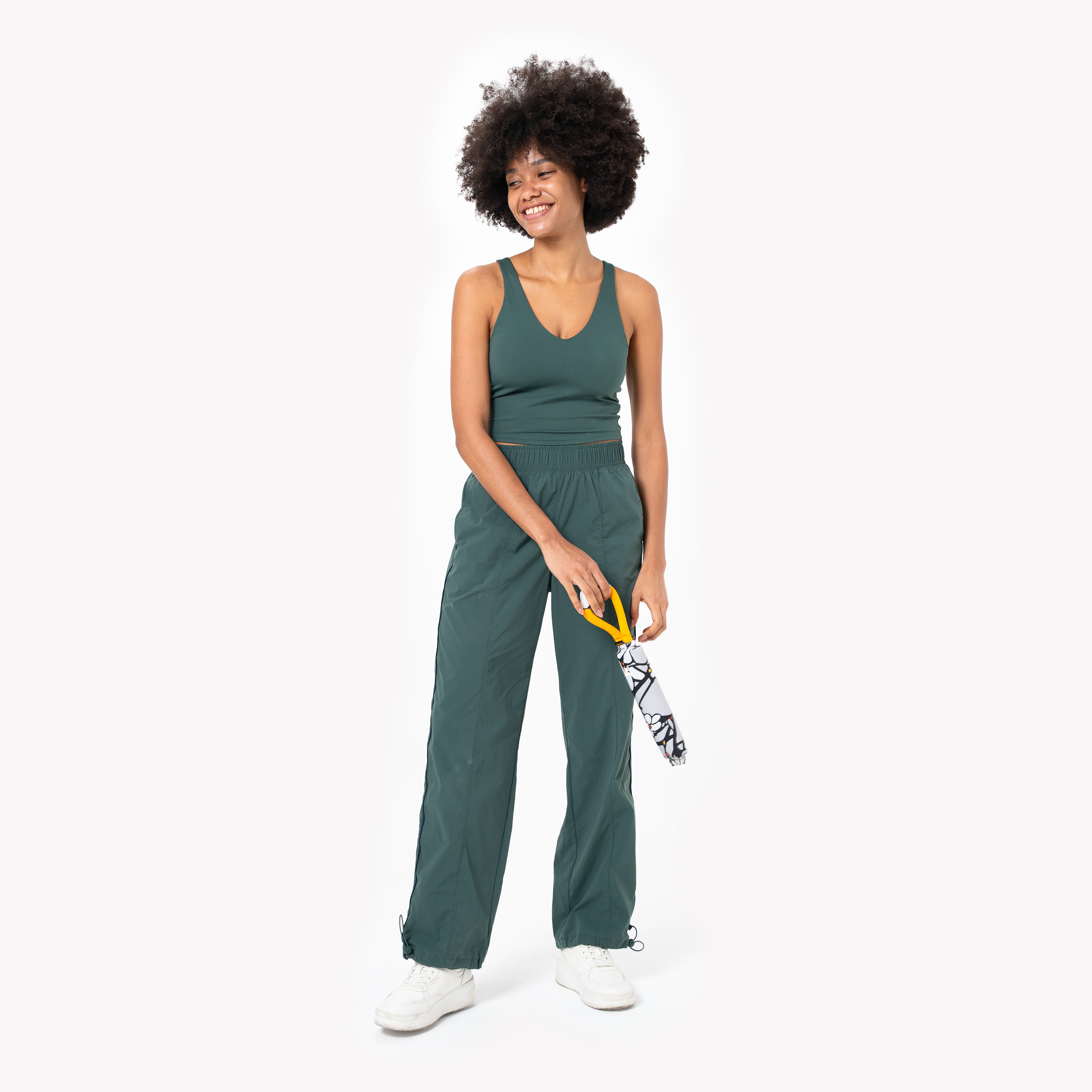 Model holding the OllyDog Tugger interactive dog toy in Magnolia print by the yellow handle, showcasing the floral-patterned body against a white background #color_magnolia