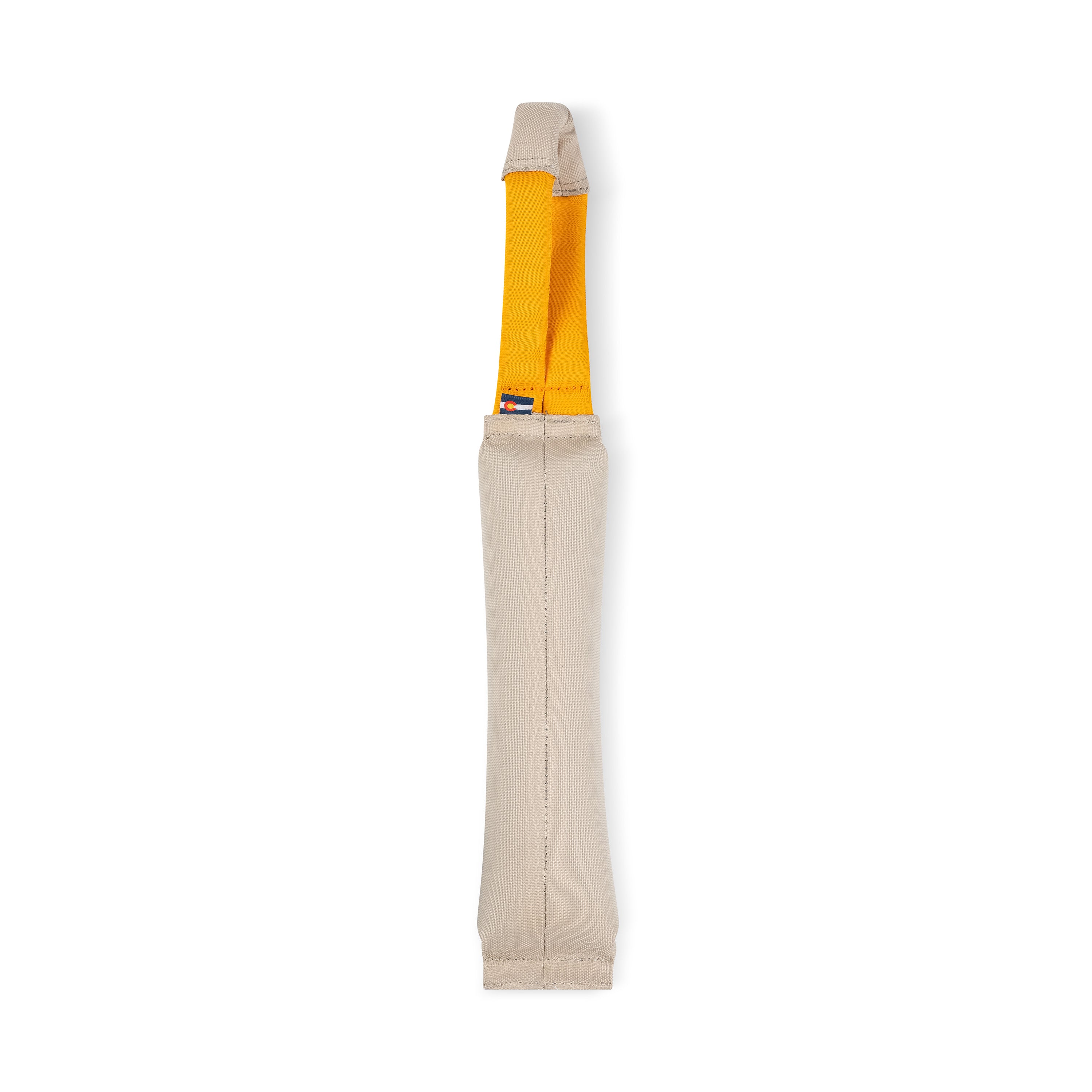 Back view of the OllyDog Tugger dog toy in Con Leche color, showing the durable recycled fabric body and sturdy yellow handle designed for tugging, fetching, and interactive play #color_con leche