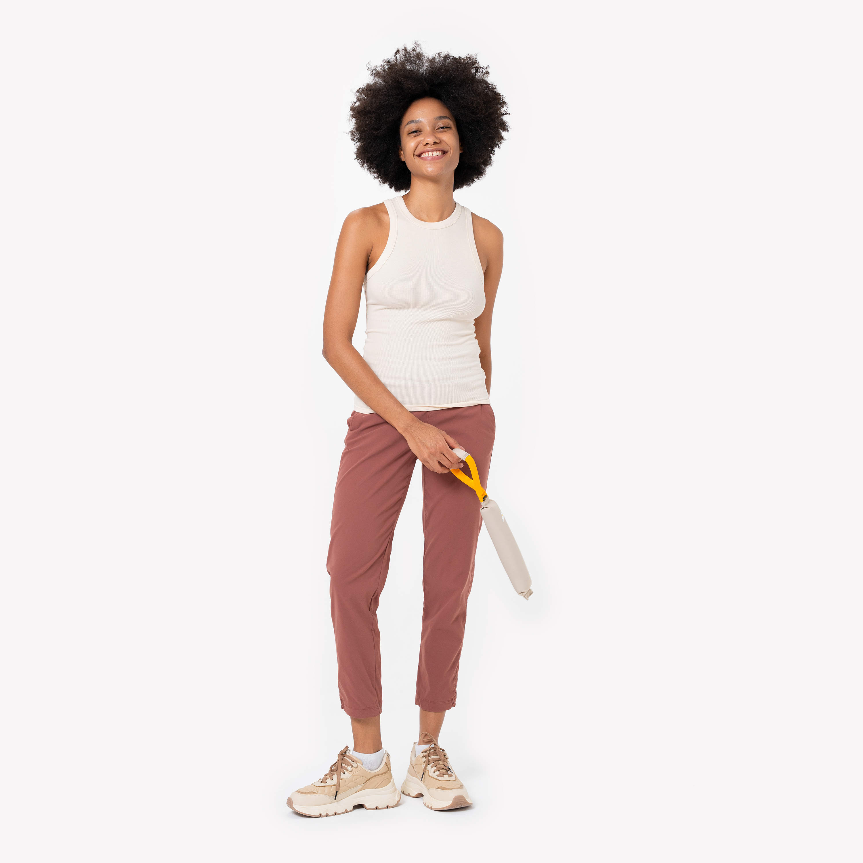 Person holding the OllyDog Tugger dog toy in Con Leche color by the sturdy yellow handle. The toy is designed for interactive play, tugging, and fetching, made from recycled, non-toxic materials #color_con leche