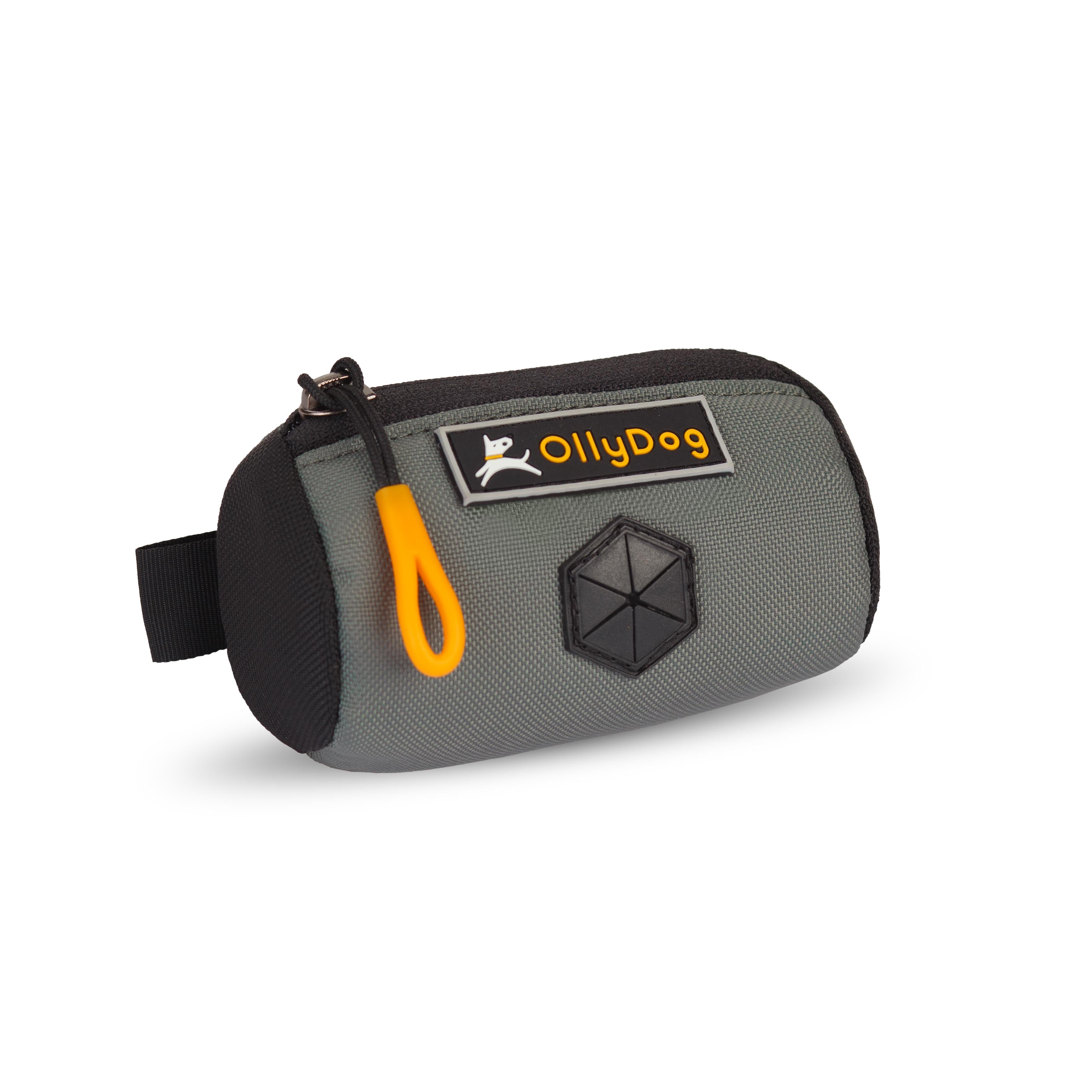 Angled front view of OllyDog’s Scoop Pick Up Bag in Juniper. This poop bag dispenser features a zipper closure and a snap button for quick attachment to a belt loop, making it a handy doggie bag holder for leash. The rubber dispensing cover ensures easy access to dog waste bags. #color_juniper