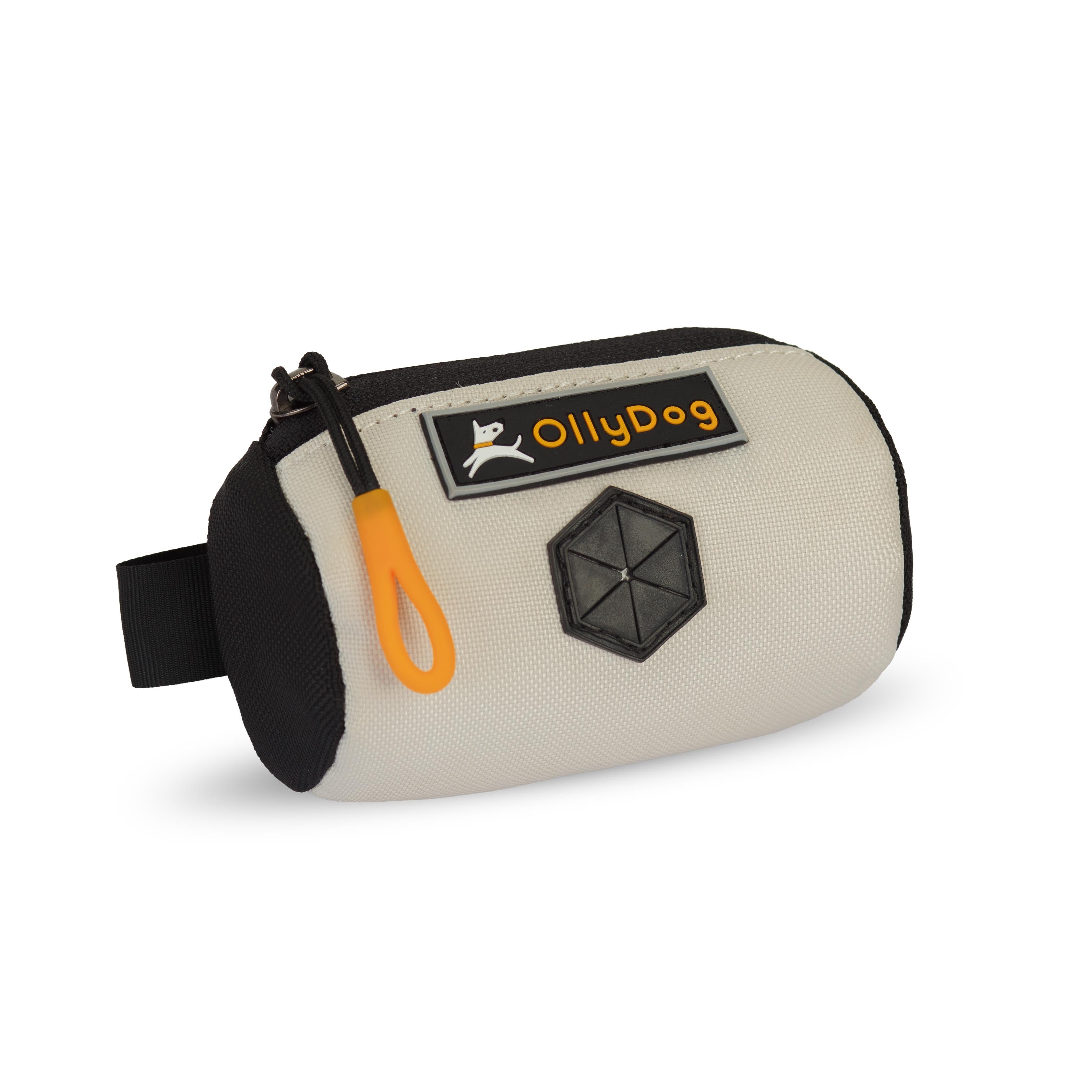 Angled front view of OllyDog’s Scoop Pick Up Bag in Bluff. This poop bag dispenser features a zipper closure and a snap button for quick attachment to a belt loop, making it a handy doggie bag holder for leash. The rubber dispensing cover ensures easy access to dog waste bags. #color_bluff