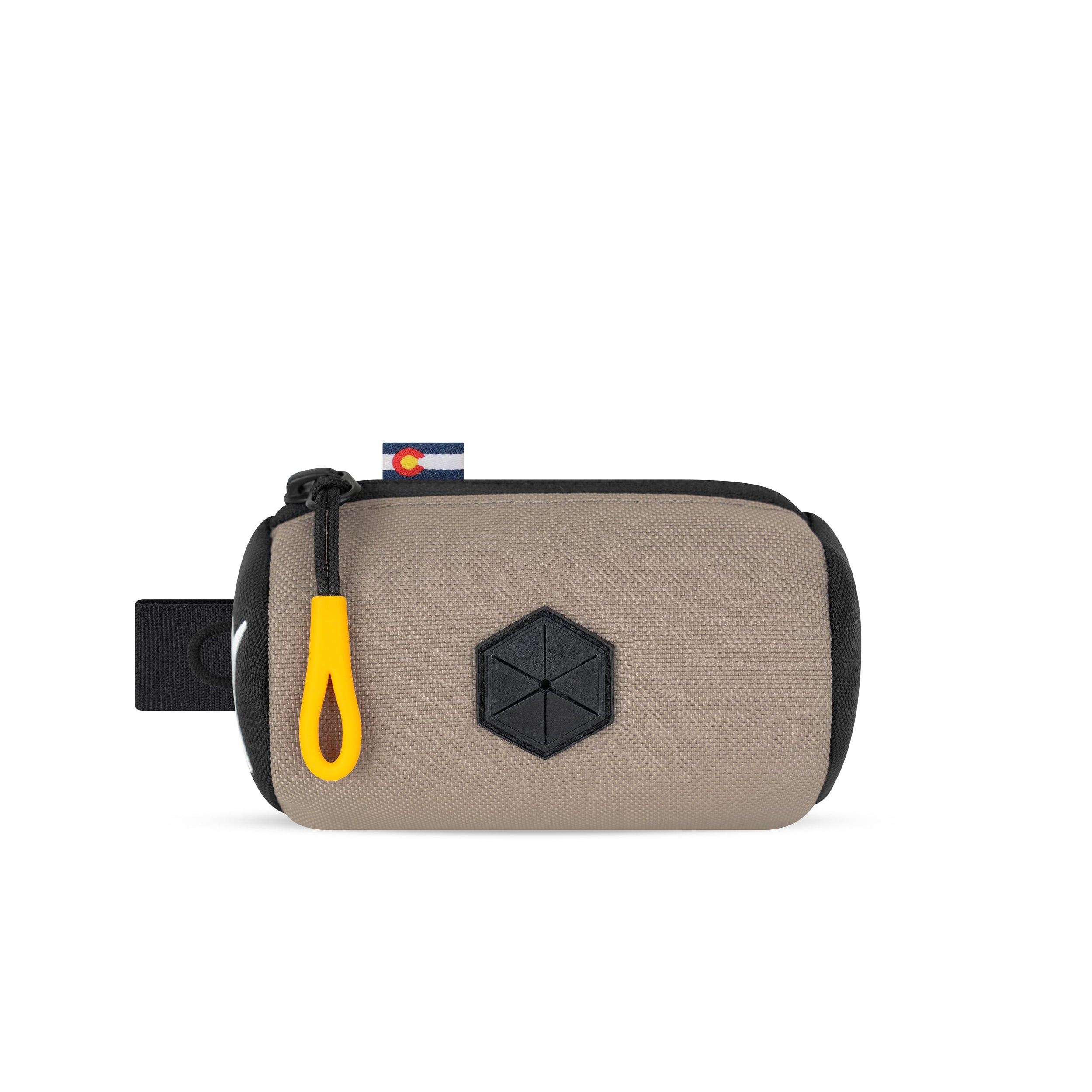 Front view of the OllyDog Scoop Pick Up Bag in dune color, showcasing the 100% recycled polyester design, zippered closure, and integrated waste bag dispenser. #color_dune