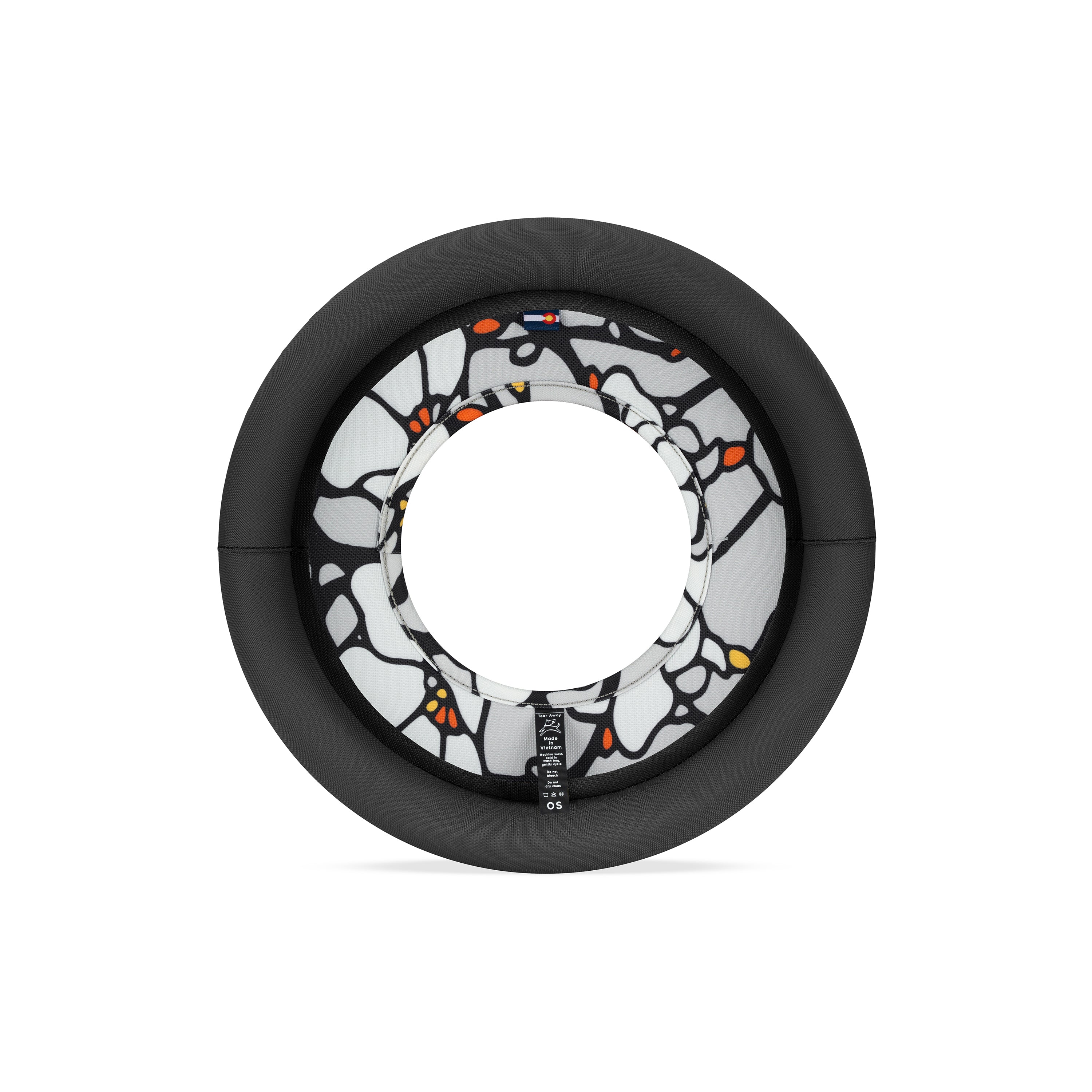 Back view of Magnolia Super Flyer dog frisbee with black padded rim and bold black and white floral center featuring orange accents and product label #color_magnolia