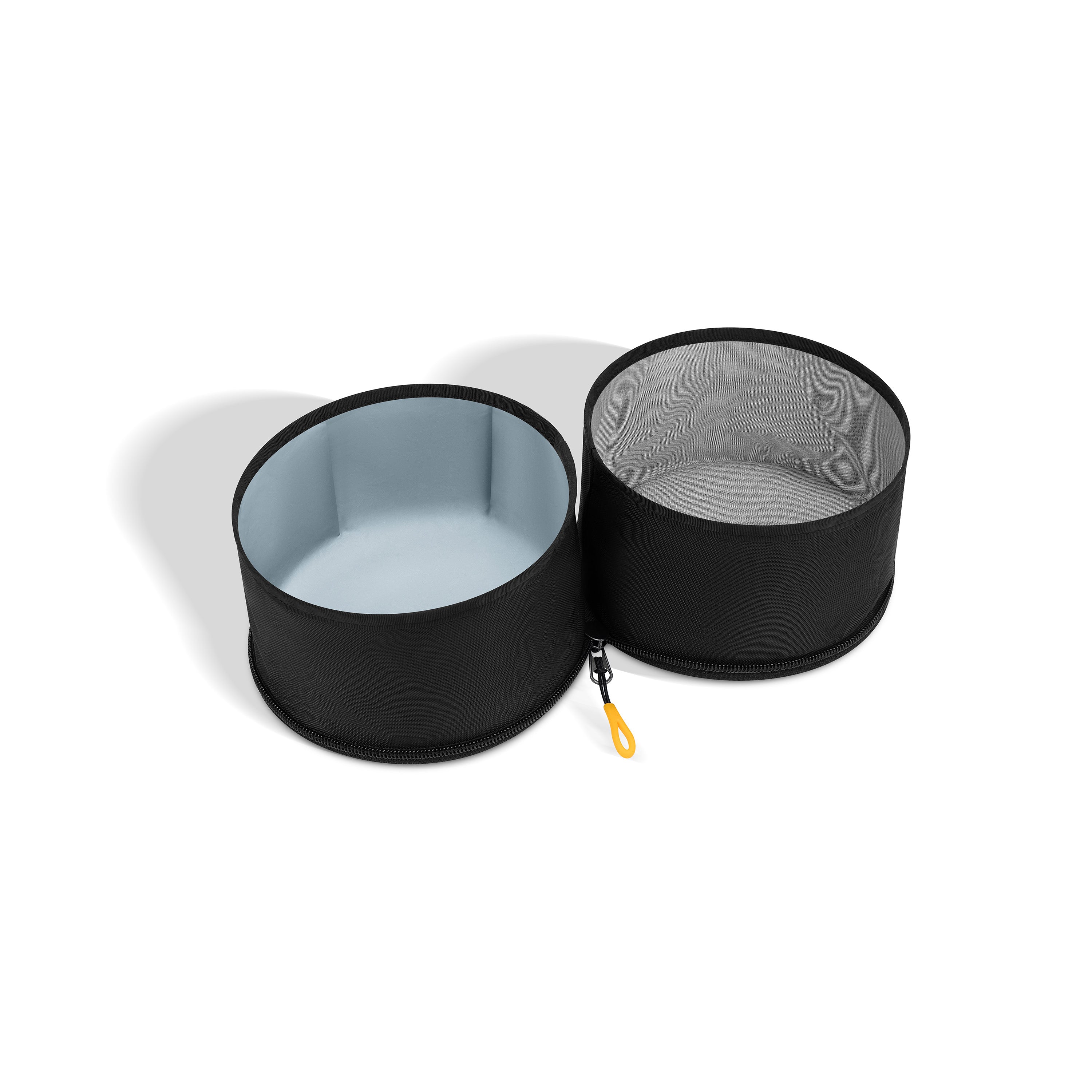 Two black OllyDog Superbowl collapsible dog bowls connected by black fabric. One bowl has a light-colored interior, and the other is empty. A yellow loop for attachment is visible #color_raven