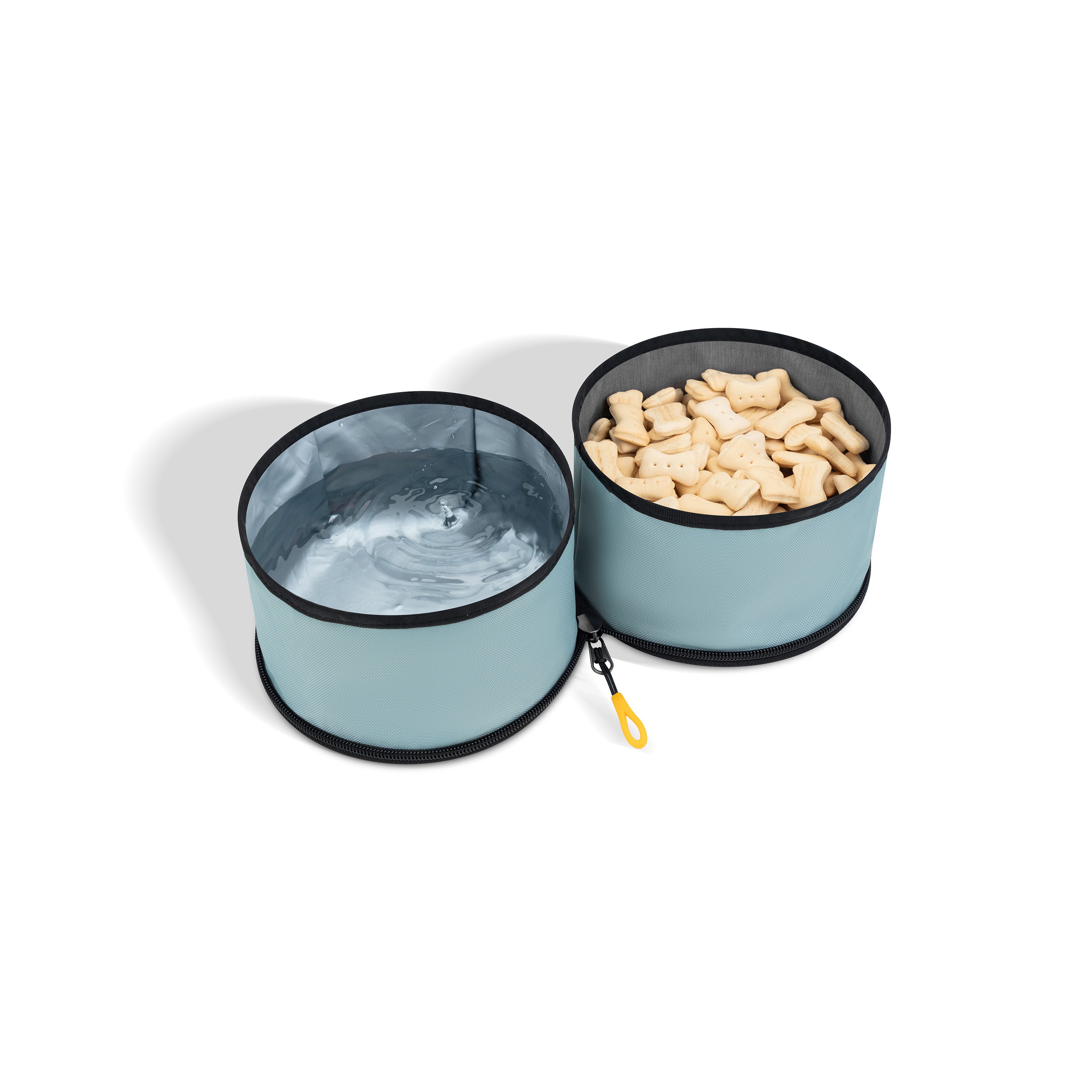 Two light blue OllyDog Superbowl collapsible dog bowls connected by light blue fabric. One bowl has a light-colored interior, and a yellow loop for attachment is visible #color_st. lucia