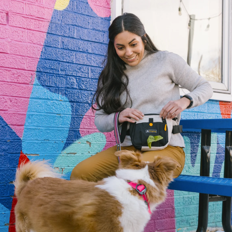 A woman wearing OllyDog’s Backcountry Day Bag in Bluff, a dog walking waist pack perfect for hiking with dogs. This essential piece of dog hiking gear is designed for comfort and functionality on dog friendly trails. #color_bluff