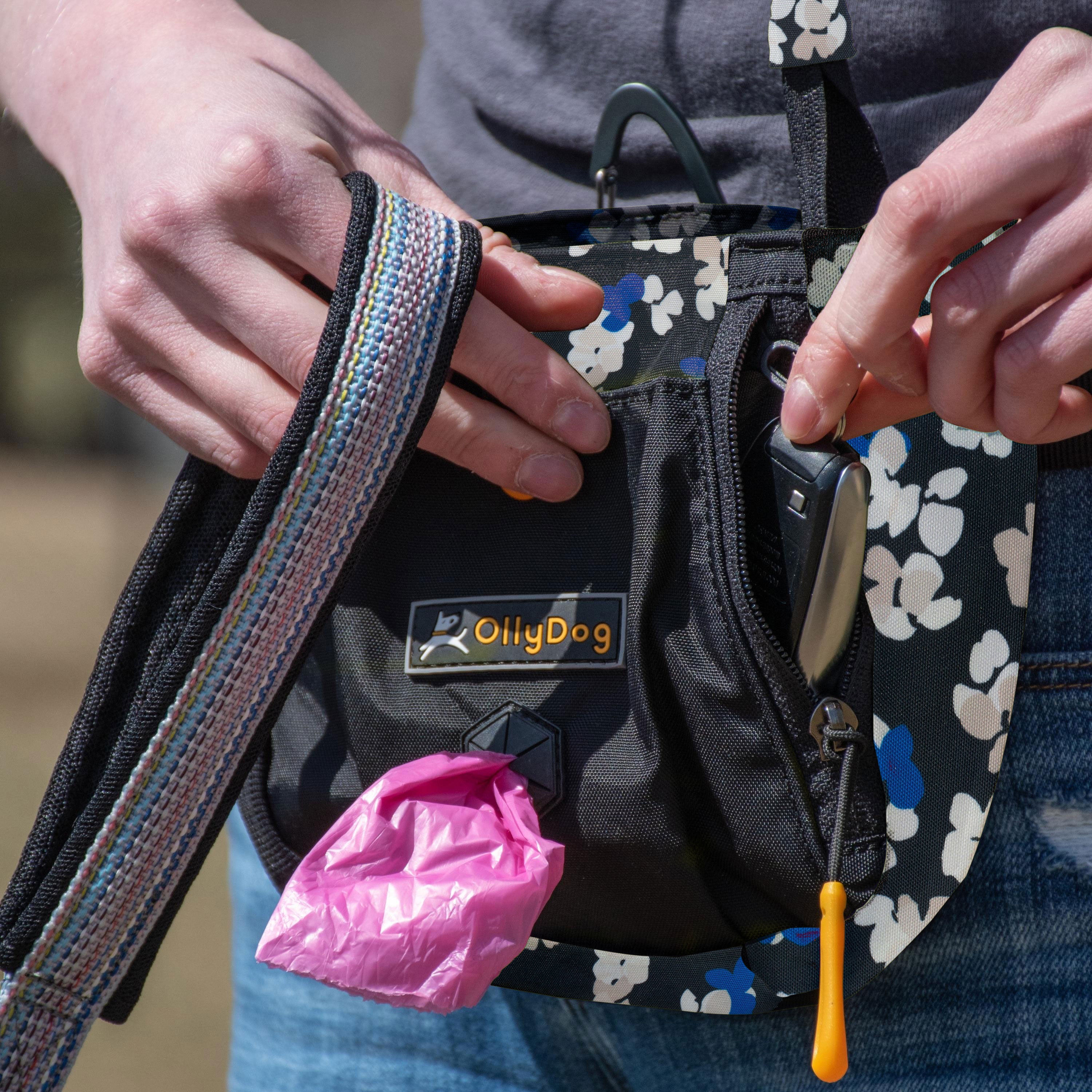 A person in jeans wearing OllyDog’s Backcountry Day Bag in Lotus, a dog walking waist pack perfect for hiking with dogs. This essential piece of dog hiking gear is designed for comfort and functionality on dog friendly trails. #color_lotus