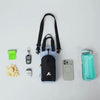 Close-up video showing a person placing or retrieving a water bottle from the leak-proof main compartment and adjustable drawstring opening of the OllyDog OllyCaddy dog walking carryall in Blue Heron color.