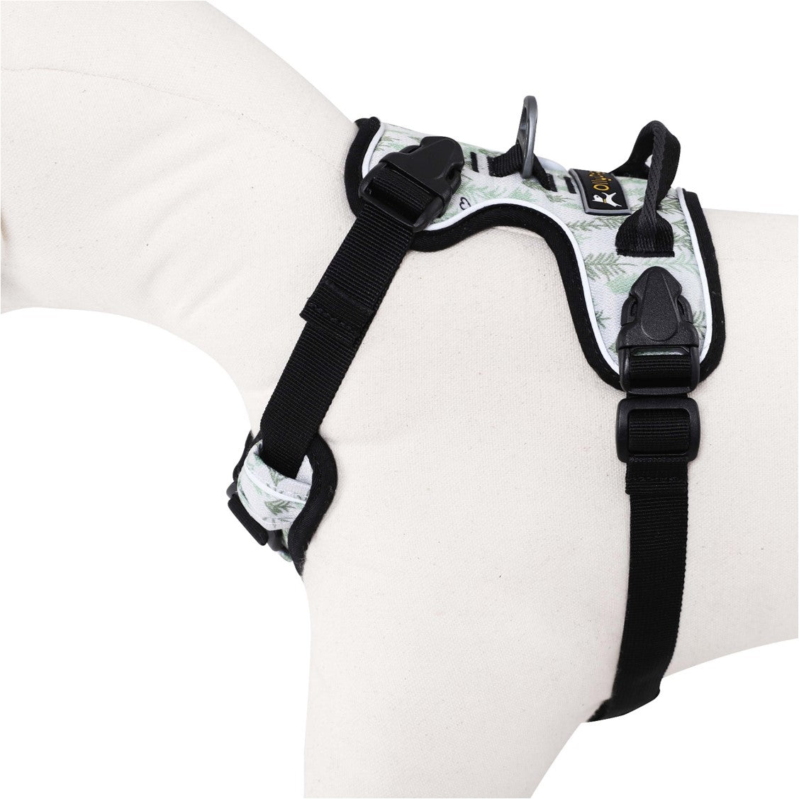 Side-angle view of a mannequin wearing the OllyDog Alpine Reflective Harness in tree hugger print, highlighting the adjustable plastic buckles, strap configuration, and durable, comfortable design made from recycled plastic bottles. #color_tree hugger print